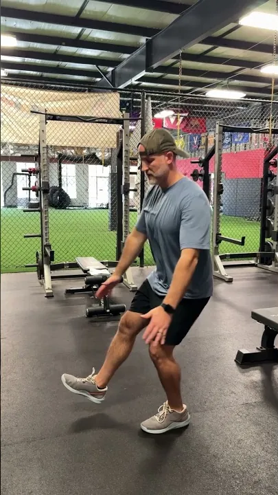 Coach Aaron demonstrating a pistol squat, a single-leg squat to full depth